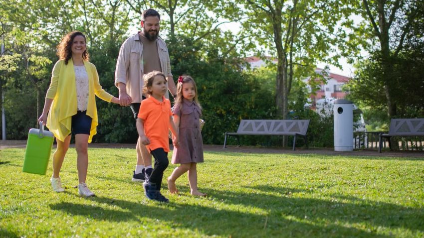 A joyful family with children strolling in a sunny Portuguese park.